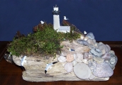 Driftwood art of seaside scene with lighthouse